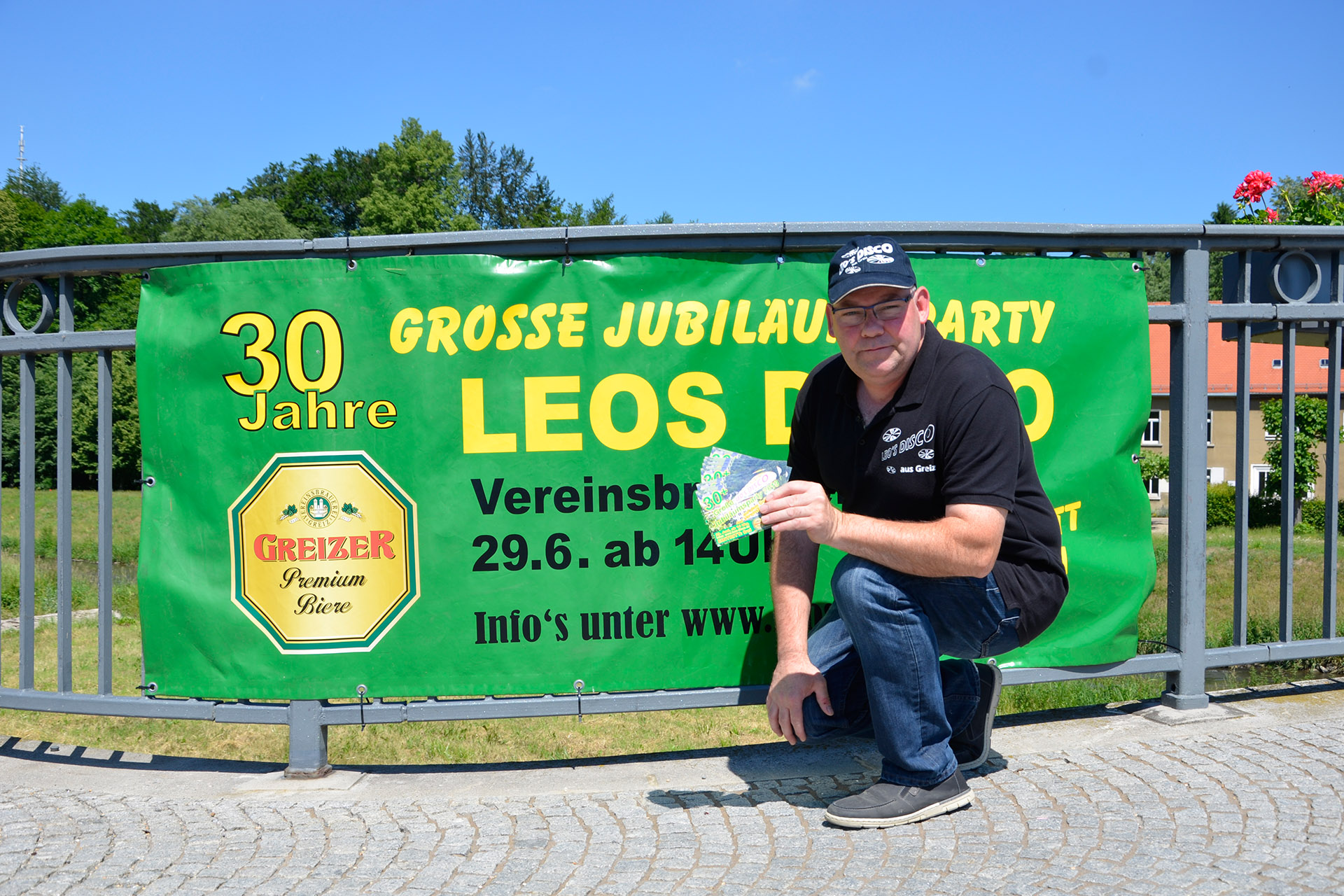 Jörg Leonhardt, alias Leo, vor seinem Werbebanner an der Greizer Freiheitsbrücke.